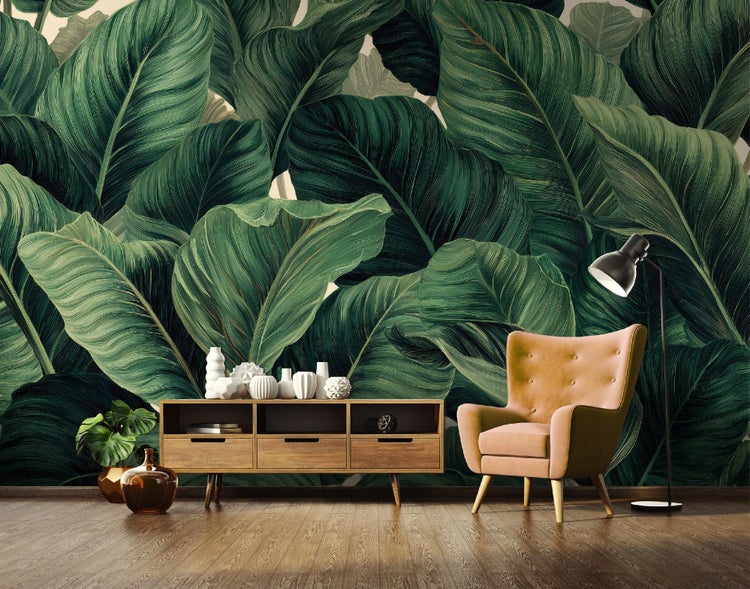 Wohnzimmer mit Fototapete mit Blattmotiv, Kommode, Sessel und Stehlampe