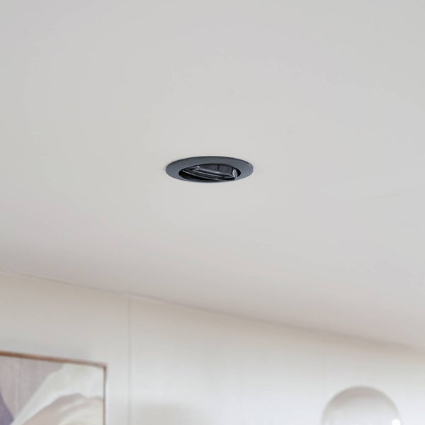 Schwarzer schwenkbarer Einbaustrahler mit rundem Gehäuse, in der Decke eingebaut.