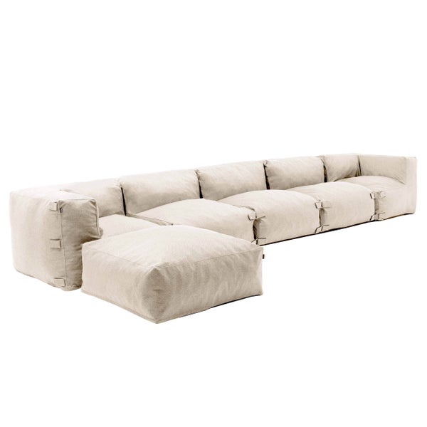 Modulares Lounge-Sofa in Beige mit weichen Polstern und Hockerelement aus wetterfestem Textilgewebe.