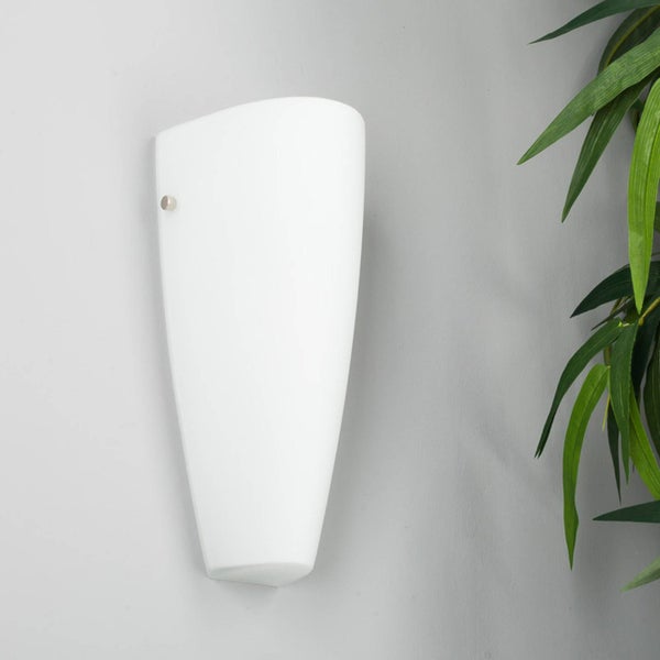 Weiße konisch geformte Wandleuchte neben einer Pflanze.