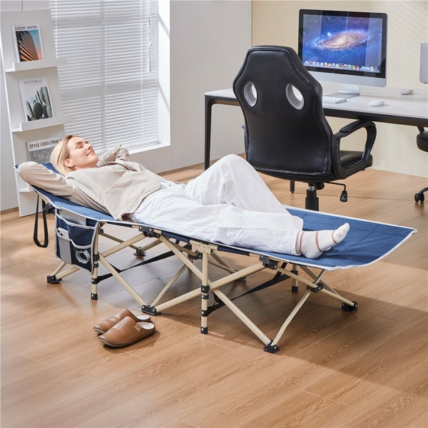 Frau entspannt sich auf einer blauen Feldbettliege mit Beistelltasche in einem Zimmer.