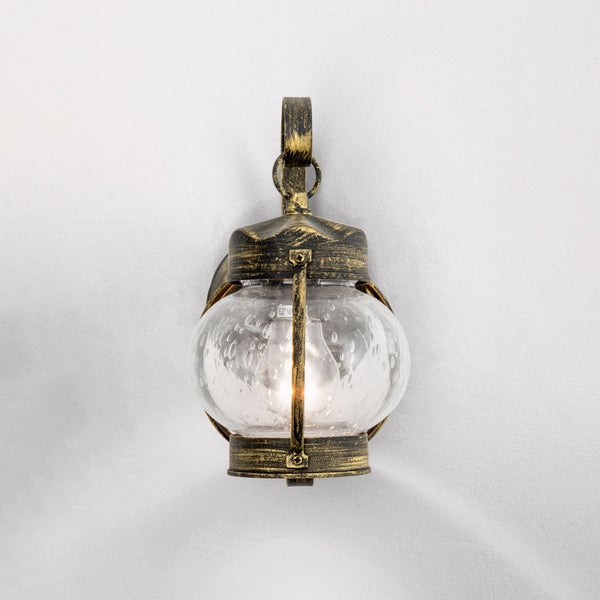 Außenwandleuchte im antiken Stil aus Metall in Schwarz und Gold mit rundem Glas und Lufteinschlüssen.