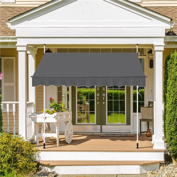 Graue Markise über einer Haustür mit weißen Säulen und Blumenwagen