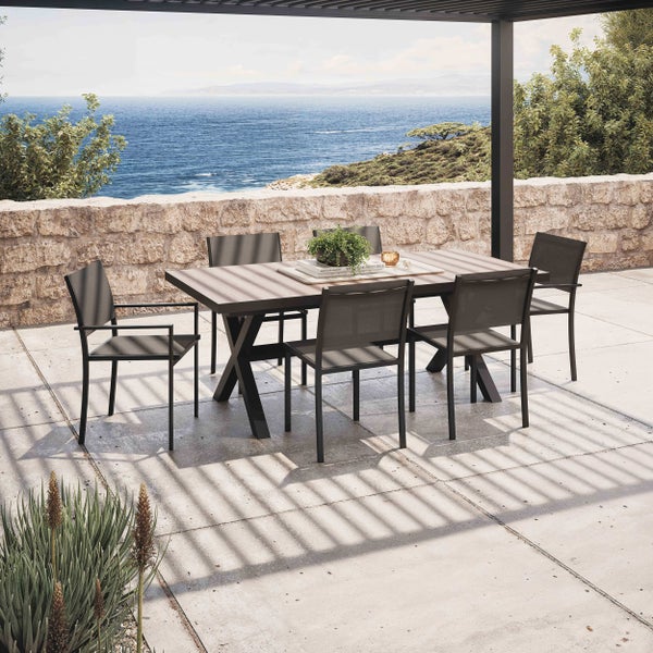 Moderne Garten-Essgruppe bestehend aus einem rechteckigen Tisch mit X-förmigem Gestell und sechs Stühlen auf einer hellen Terrasse mit Meerblick.