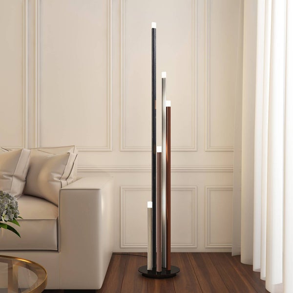 Moderne LED-Stehleuchte mit fünf schlanken Stäben unterschiedlicher Höhe in einem hellen Wohnzimmer neben einem cremefarbenen Sofa.