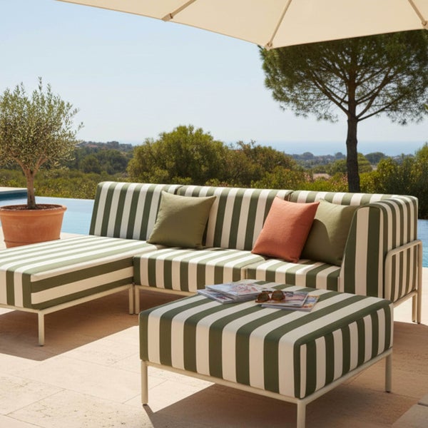 Modernes gestreiftes Outdoor-Lounge-Set auf einer Terrasse am Pool, bestehend aus einem Ecksofa und einem Hocker unter einem Sonnenschirm.