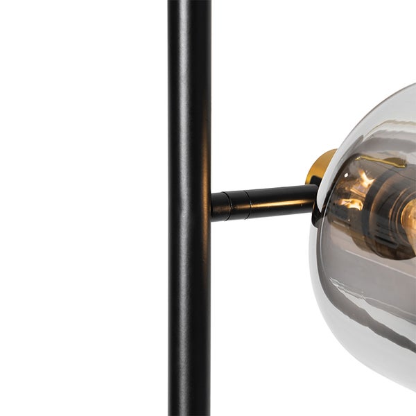 Detailansicht einer Stehlampe mit Glasschirm und Metallgestell