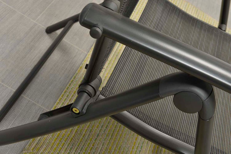 Detailaufnahme eines Gartenstuhlgestells aus Metall und Textilgewebe, zeigt die Gelenke und die Konstruktion.