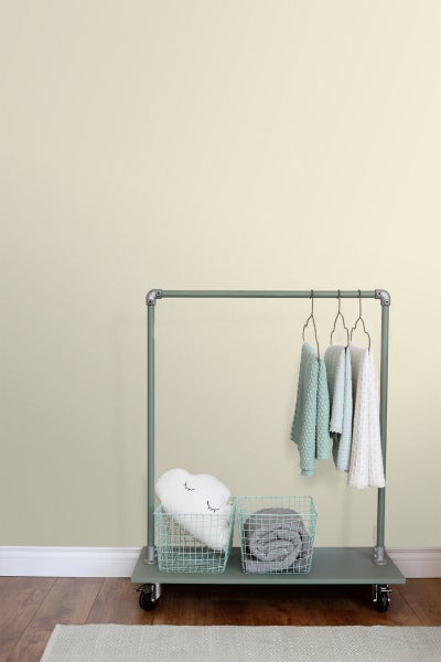 Zimmeransicht mit Kleiderständer, Körben, Kissen, Decken und Textilien