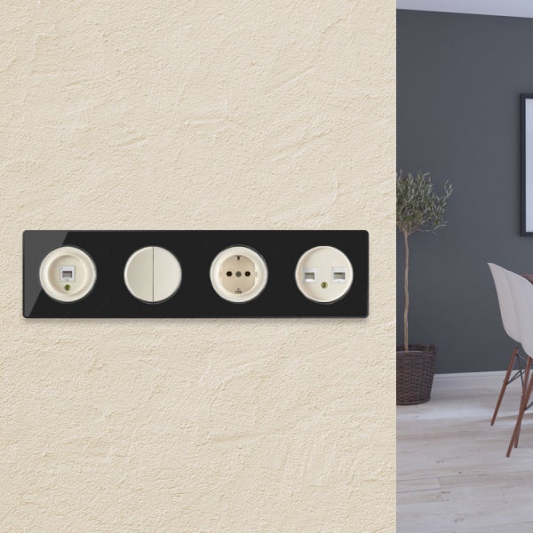Vierfach Schalter und Steckdosen Kombination mit rundem Design auf einer strukturierten Wand in einem Wohnraum.
