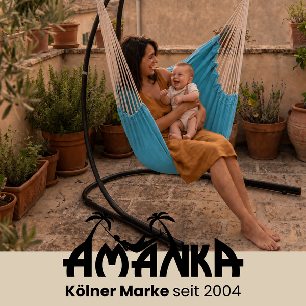 Eine Frau mit ihrem Baby in einer freistehenden Hängematte auf einer Terrasse mit vielen Pflanzen in Tontöpfen, Amanka Logo