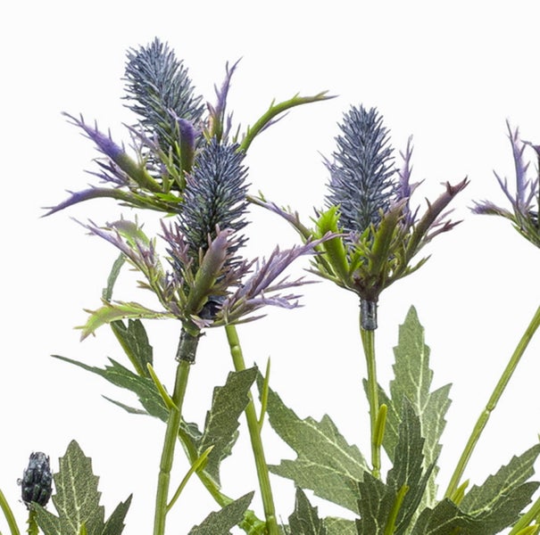 Nahaufnahme einer künstlichen Distel mit grünen Stielen, gezackten Blättern und einem blauen Blütenkopf.