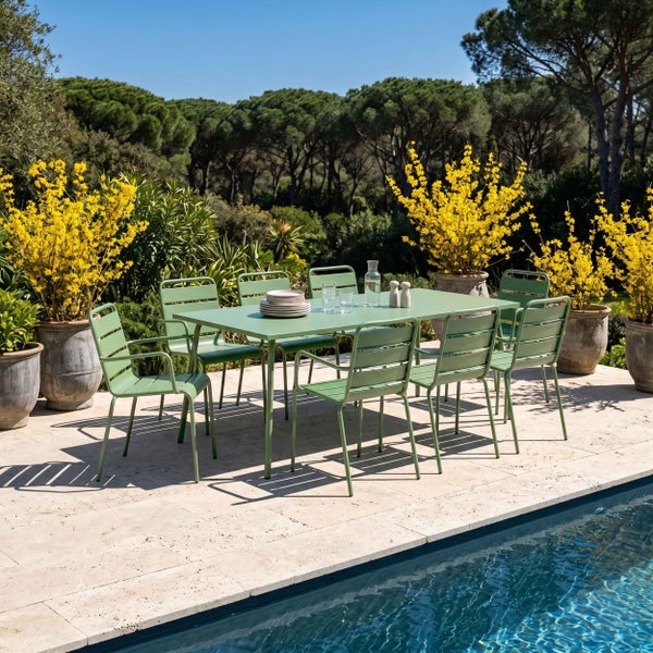 Modernes Gartenmöbel-Set aus grünem Metall mit rechteckigem Tisch und Stühlen auf einer hellen Steinterrasse neben einem Pool.