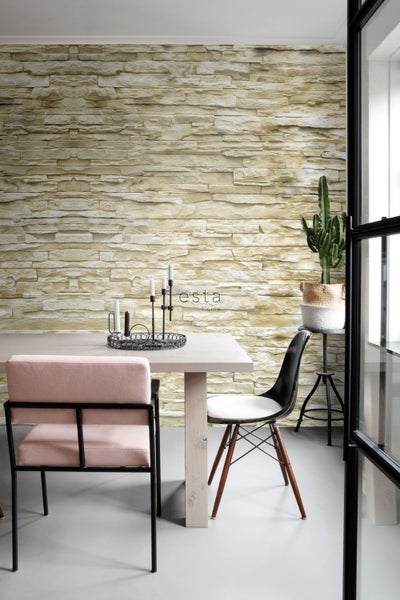 Esszimmer mit Steintapete, Tisch, Stühlen und Dekoration