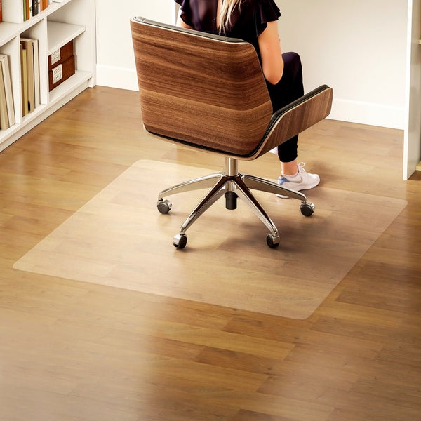 Transparente Bodenschutzmatte für Hartböden unter einem Bürostuhl in einem hellen Arbeitszimmer mit Holzboden.