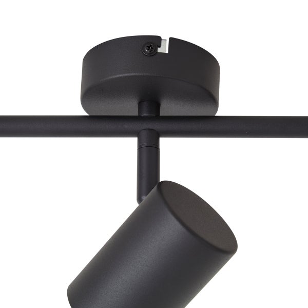 Detailansicht eines verstellbaren Deckenspots aus Metall an einer Deckenhalterung.