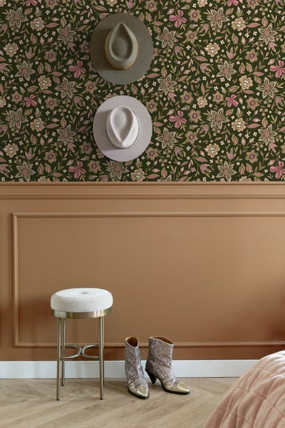 Florale Tapete über braunen Wandpaneelen mit Hüten, einem weißen Hocker und glitzernden Stiefeln.