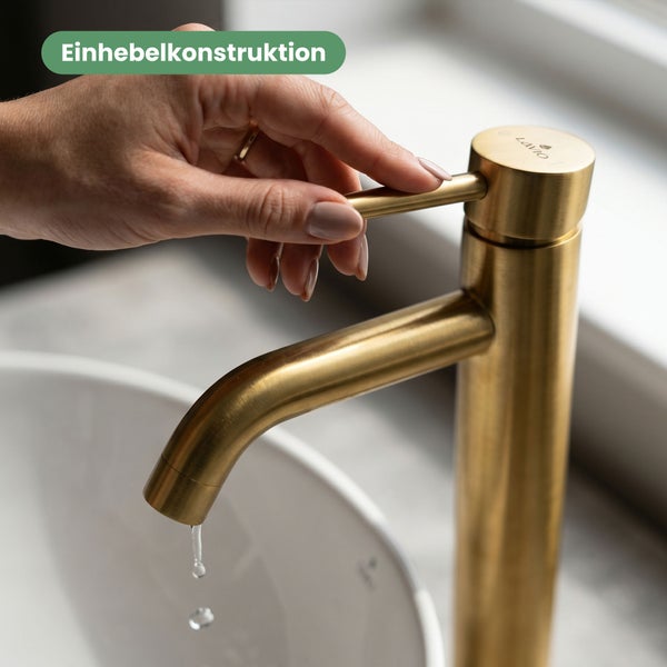Hand bedient eine goldfarbene Lavio Einhand-Waschtischarmatur mit Einhebelkonstruktion über einem weißen Waschbecken.