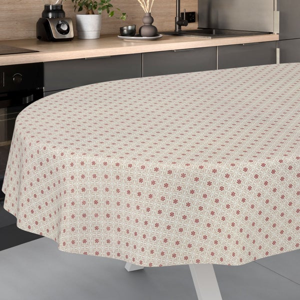 Runde Tischdecke mit grafischem Blumenmuster auf einem Esstisch in einer hellen, modernen Küche mit Schränken und Küchengeräten.