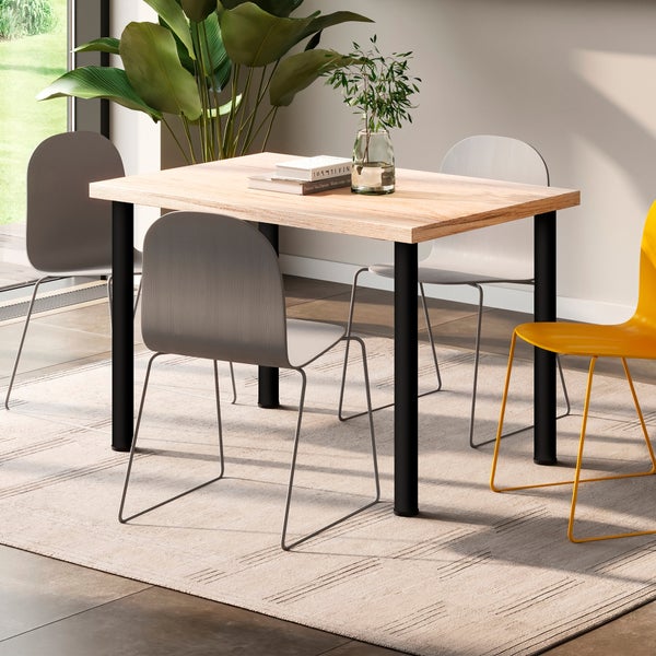 Esszimmertisch mit Holzplatte und vier Stühlen in einem hellen, modern eingerichteten Raum mit Teppich und großen Zimmerpflanzen.