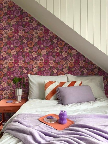 Schlafzimmer mit Blumenmuster-Tapete, Bett und Nachttisch