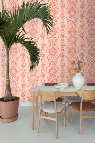 Wohnraum mit gemusterter Tapete, Esstisch und Zimmerpflanze im Topf