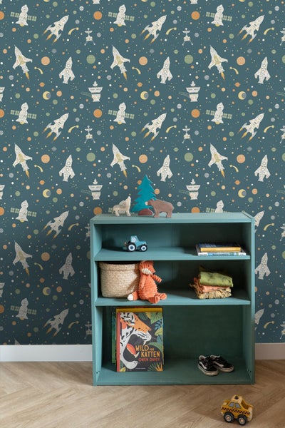 Kindertapete mit Weltraummotiv, Raketen und Planeten hinter einem offenen Regal mit Spielzeug und Büchern.