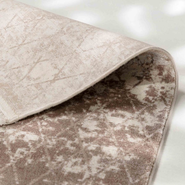 Nahaufnahme eines gemusterten Teppichs mit umgeknickter Ecke zur Darstellung von Oberseite und Rückseite.