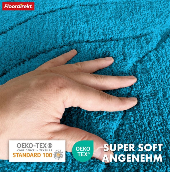 Detailansicht eines türkisfarbenen Teppichs mit Hand und den Siegeln Öko-Tex Standard 100 und Öko-Tex