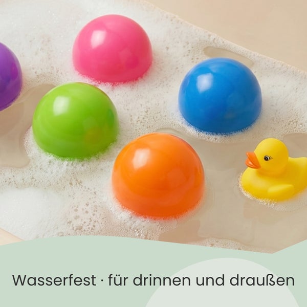 Bunte Bälle und eine gelbe Badeente schwimmen in Wasser mit Schaum, wasserfest für drinnen und draußen.