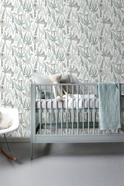 Babyzimmer mit Kinderbett und Dschungeltapete mit Affenmotiven