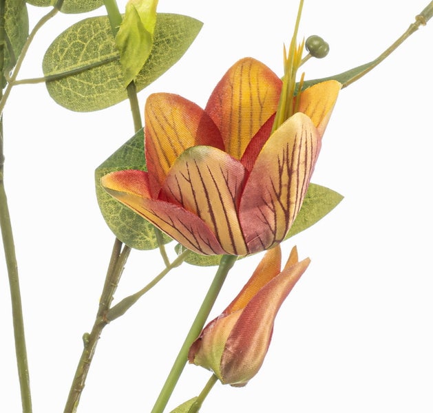 Künstliche Blume mit orange-gelb gestreiften Blütenblättern und grünen Blättern.