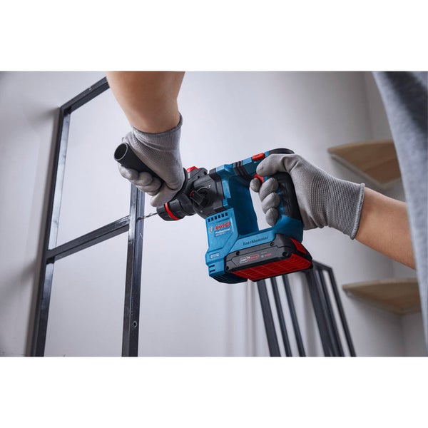 Person verwendet einen Bosch Professional Akku Bohrhammer zum Bohren in ein Metallregal.
