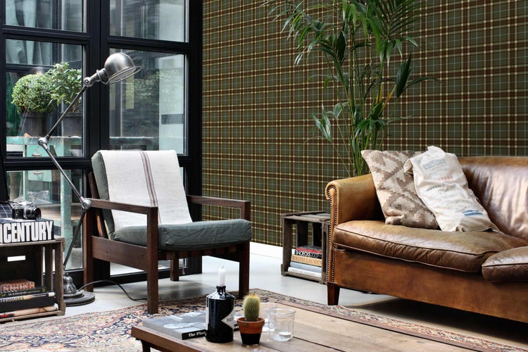 Tapete mit Schottenmuster in einem rustikalen Wohnzimmer mit Ledersofa, Holzsessel und Stehlampe.