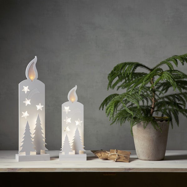 Dekorative LED Kerzen mit Sternen- und Tannenbaumdesign auf einem Tisch mit Zimmerpflanze und Geschenk