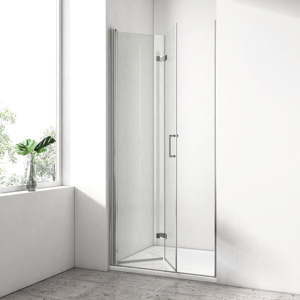 Moderne Duschkabine mit einer klappbaren Glastür, verchromten Scharnieren und einem Griff in einem hellen Badezimmer mit Steinboden.