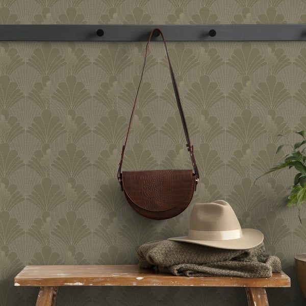 Eine Garderobe mit einer braunen Tasche, einem Hut und einem Pullover vor einer gemusterten Tapete