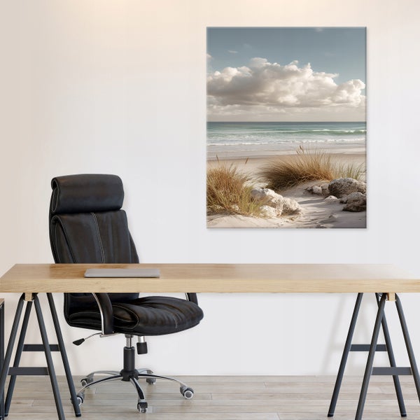 Büro mit Schreibtisch aus Holz, schwarzem Bürostuhl und einem Wandbild mit Strandmotiv an einer weißen Wand.