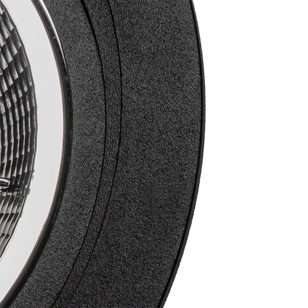 Nahaufnahme eines schwarzen, runden Einbaustrahlers mit strukturierter Oberfläche und facettiertem Reflektor.