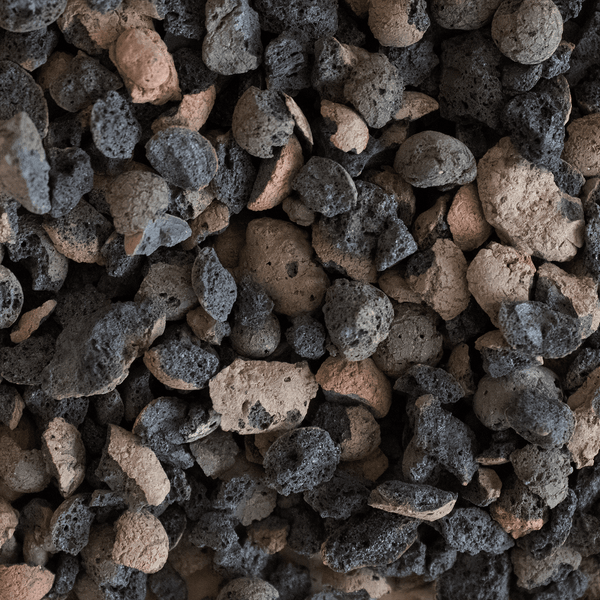 Nahaufnahme von porösem Lavamulch aus dunklem und rötlichem Lavagestein zur Bodenabdeckung und Beetgestaltung.