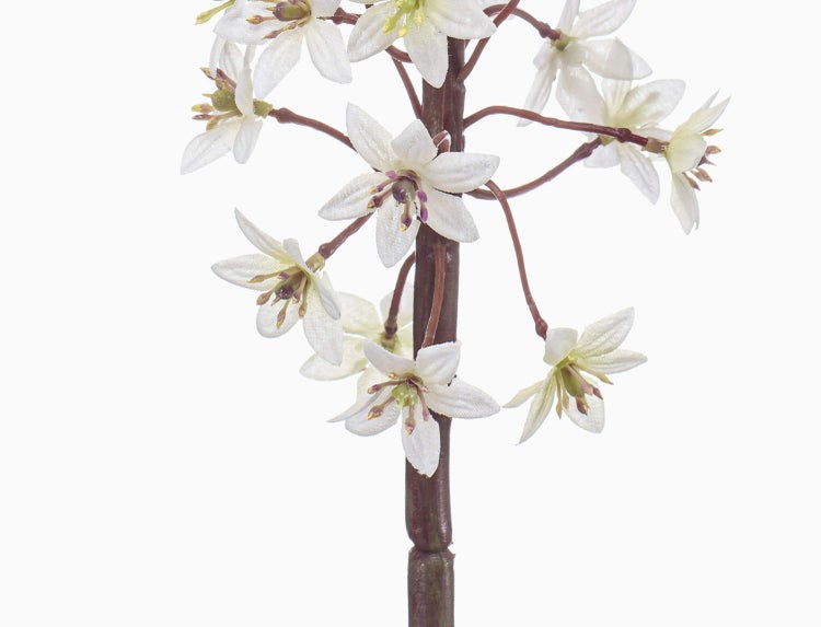 Künstlicher Blumenzweig mit kleinen weißen Blüten.