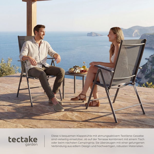 Zwei Personen sitzen auf grauen Klappstühlen aus Textilene auf einer hellen Terrasse mit Meerblick. tectake garden Logo.