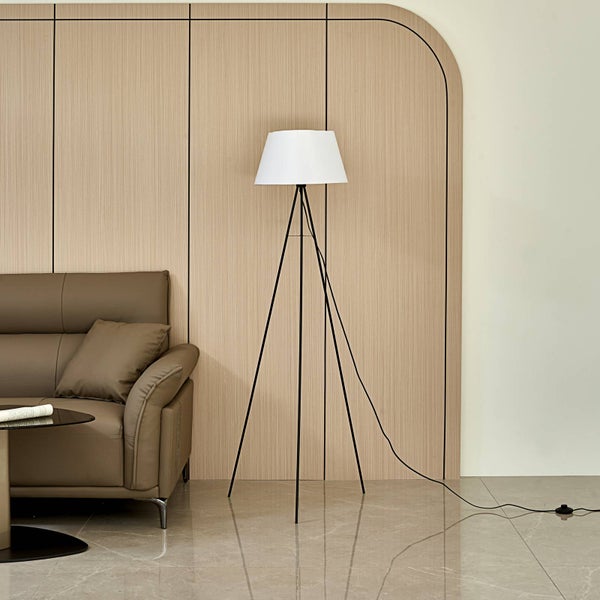 Stehleuchte mit weißem Schirm und schwarzem Stativfuß in einem Wohnzimmer