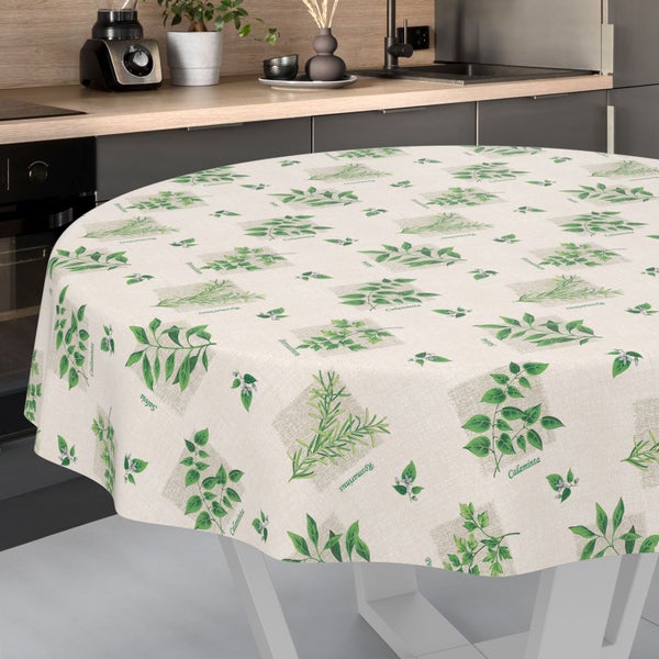 Runde Tischdecke mit Kräutermotiven wie Rosmarin und Salbei auf einem runden Tisch in einer modernen Küche.