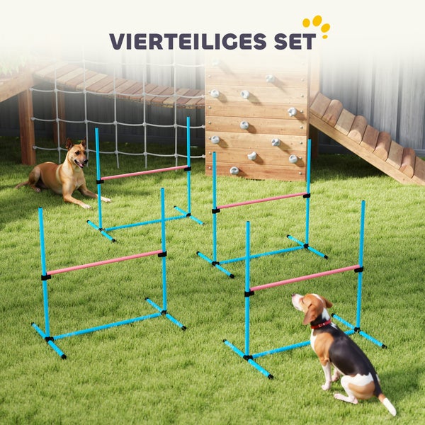 Vierteiliges Hunde-Agility-Hürdenset auf einer Wiese mit zwei Hunden und einer Kletterwand im Hintergrund.