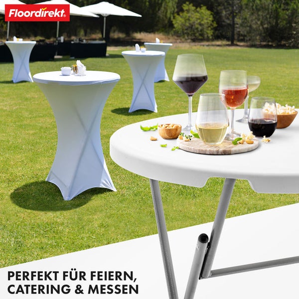 Mehrere runde Stehtische mit weißen Stretchhussen auf einem Rasen für ein Event im Freien. Im Vordergrund Getränke und Snacks. Floordirekt Logo.