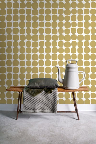 Dekorative Szene mit Tapete, Bank, Kissen, Decke und Gießkanne