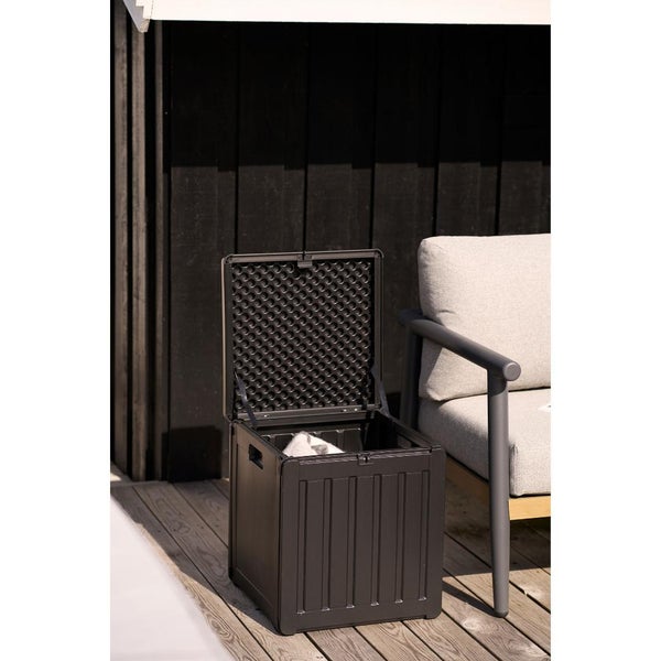 Geöffnete Garten-Auflagenbox aus Kunststoff in Holzoptik auf einer Holzterrasse neben einem Gartenstuhl.