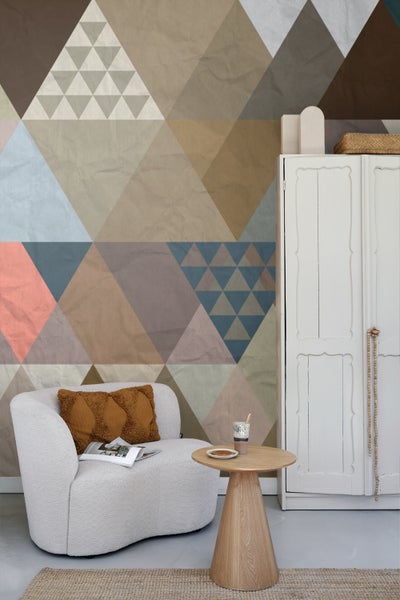 Wohnzimmer mit geometrischer Tapete, Sessel und Beistelltisch