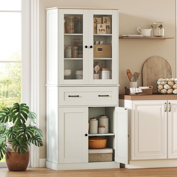 Küchenschrank im Landhausstil mit Vitrine, Schublade und Unterschrank in einer hellen, organisierten Küche neben einer Pflanze.